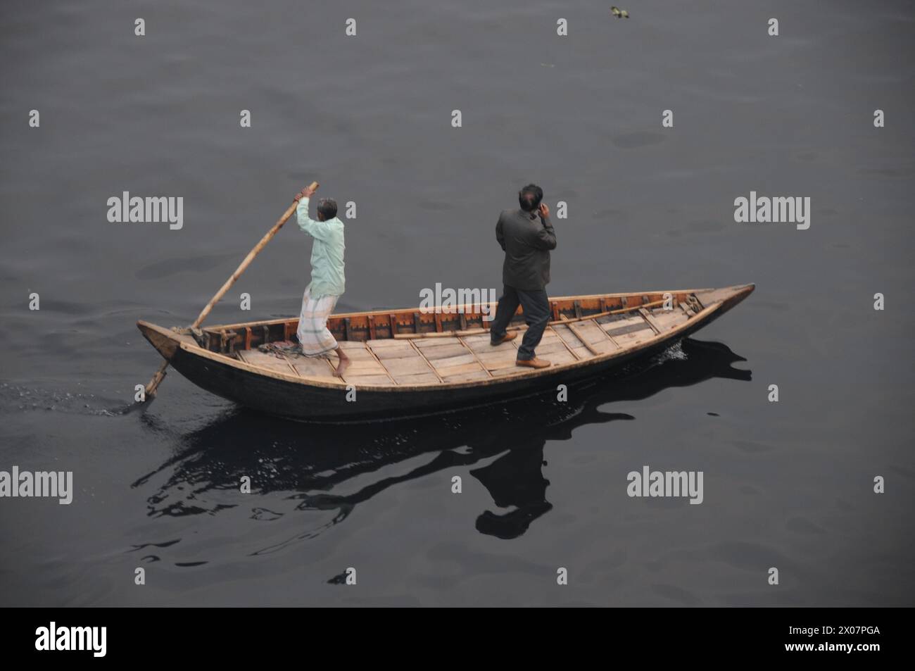 Uomo d'affari che prende il tradizionale taxi fluviale, Dacca Foto Stock