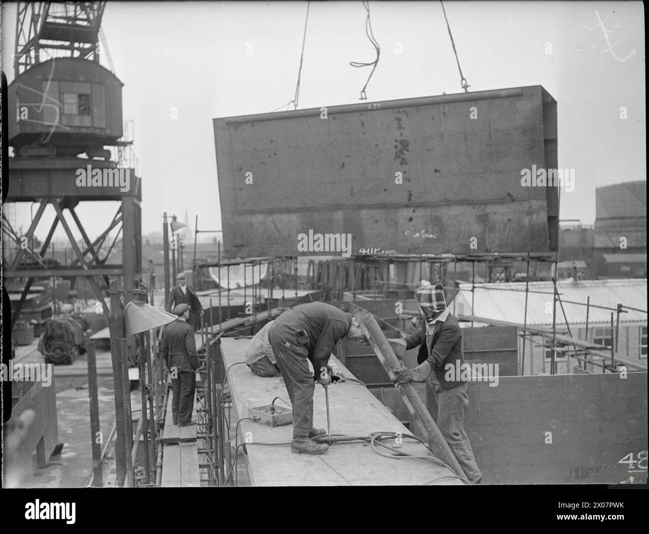 Presso il cantiere navale Henry Scarr Ltd, Hessle, vicino a Hull, personale della Royal Navy, tra cui una donna, ha posizionato la tasca laterale di una nave su un'imbarcazione prefabbricata durante la costruzione in tempo di guerra. Foto Stock Presso il cantiere navale Henry Scarr Ltd, Hessle, vicino a Hull, personale della Royal Navy, tra cui una donna, ha posizionato la tasca laterale di una nave su un'imbarcazione prefabbricata durante la costruzione in tempo di guerra. Foto Stock