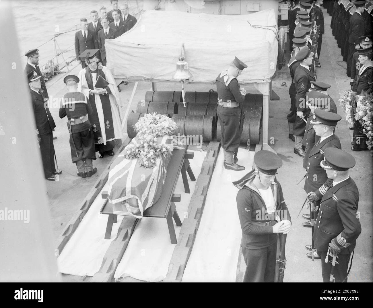 CAPITANO WALKER SEPOLTO IN MARE. 12 LUGLIO 1944, A BORDO DELLA HMS HESPERUS, NELLA BAIA DI LIVERPOOL. DOPO IL SERVIZIO PRESSO LA CATTEDRALE DI LIVERPOOL, IL CORPO DEL CAPITANO F J WALKER, CB, DSO, RN, ACE U-BOAT FIGHTER, ERA IMPEGNATO SUL MARE ALL'INGRESSO DEL MERSEY. - I Bluejackets, con le braccia invertite, e gli ufficiali di alto livello sorvegliano la bara, mentre l'HESPERUS procede verso il mare. Nota le cariche di profondità ai piedi della bara Foto Stock