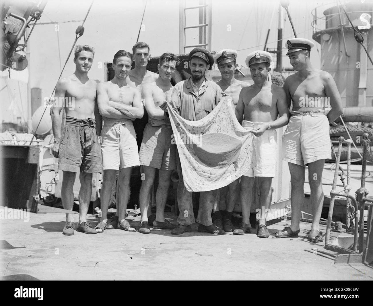 HMS Pathfinder che mostrava una bandiera giapponese catturata il 3 marzo 1945 a Colombo, data dai Royal Garwhal Rifles che il cacciatorpediniere sosteneva a Ramree Island, con otto equipaggi che esaminavano la bandiera. Foto Stock