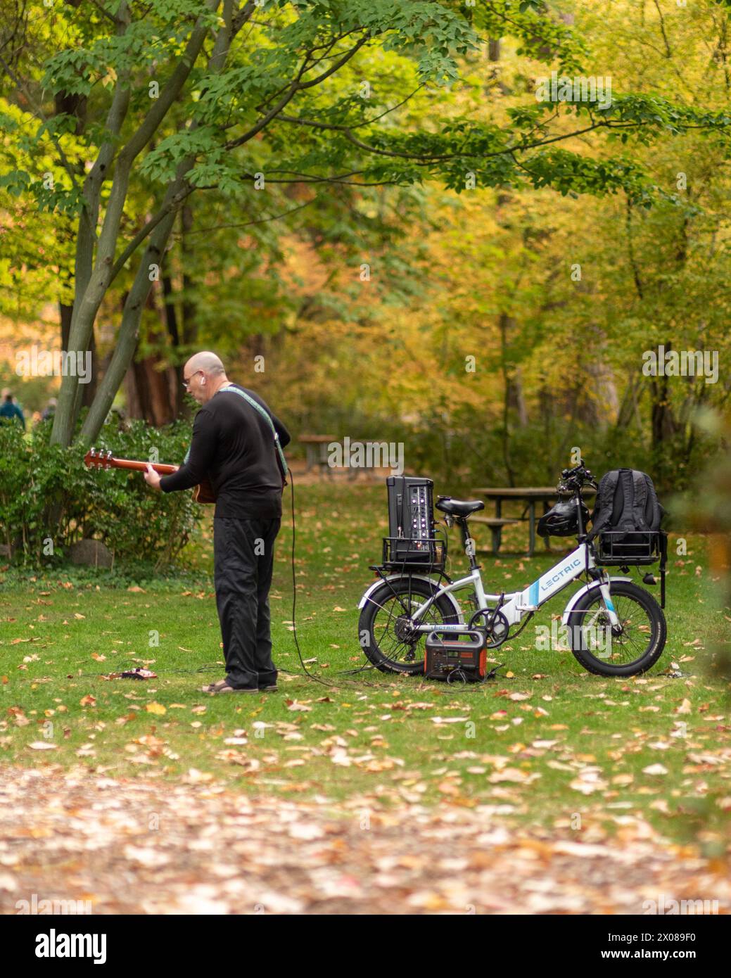 Ashland, OR, 15 ottobre 2023. Chitarrista al Lithia Park, Ashland, O, nell'autunno del 2023, con una bici lectric Foto Stock