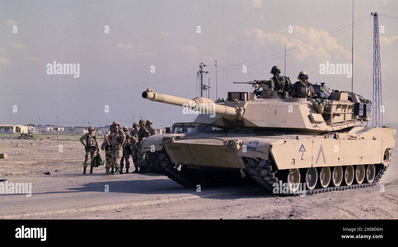 Prima guerra del Golfo: 27 marzo 1991 Un carro armato M1A1 Abrams dell'esercito americano passa un gruppo di soldati alla periferia di Safwan, nel sud dell'Iraq. Foto Stock