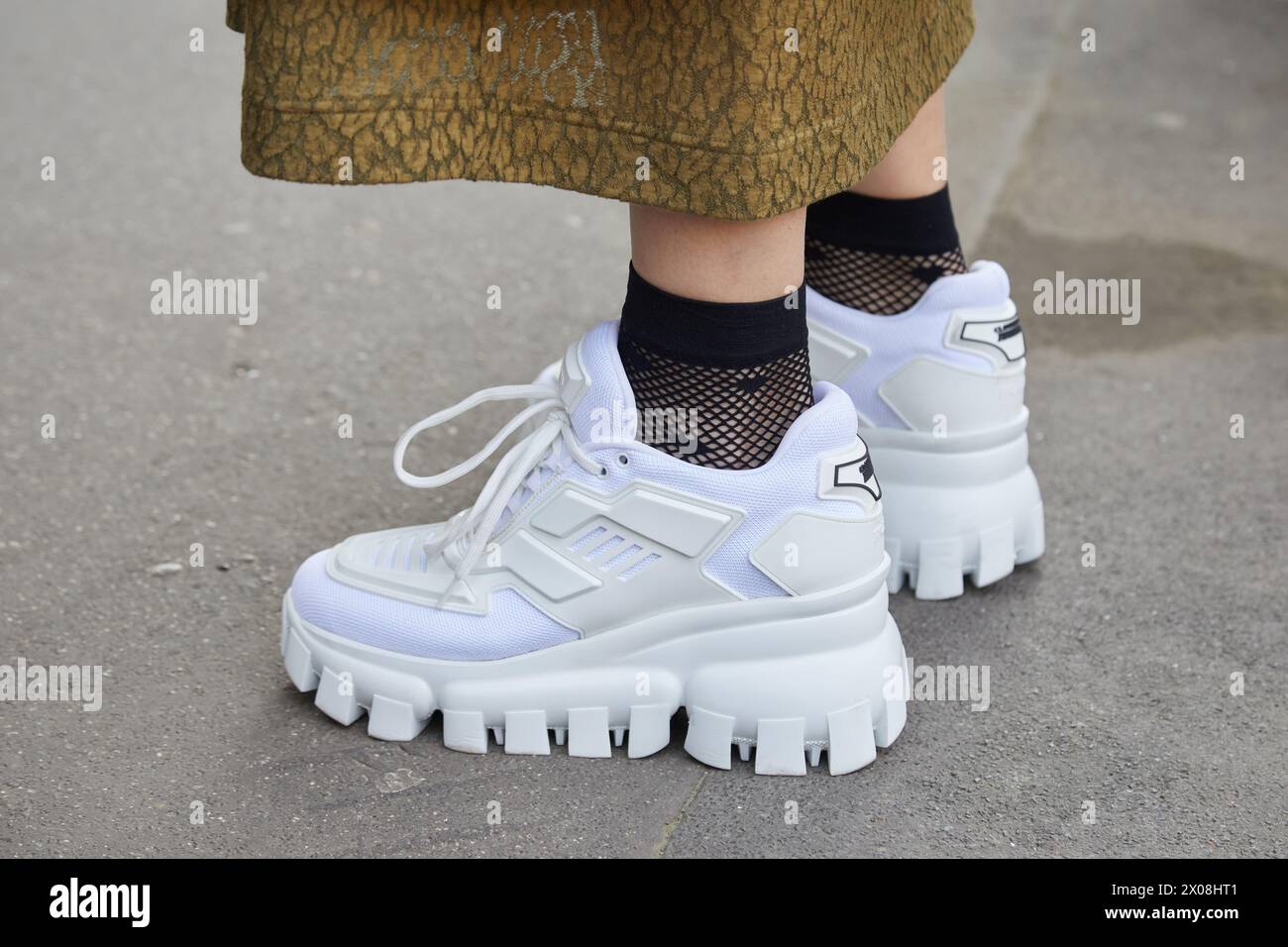 MILANO, ITALIA - 21 FEBBRAIO 2024: Donna con sneakers bianche prima della sfilata di Fendi, Milano Fashion Week Street style Foto Stock