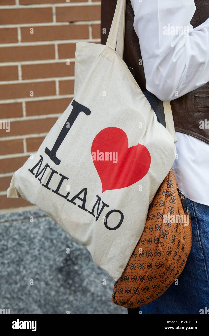 MILANO, ITALIA - 21 FEBBRAIO 2024: Donna con borsa tote con logo i Love Milano e borsa Loewe prima della sfilata di Fendi, Street styl Milan Fashion Week Foto Stock