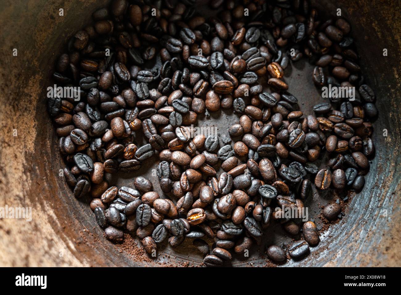 Chicchi di caffè con una consistenza ricca e tostata, catturati all'interno di una ciotola robusta, che mostra i prodotti locali di Bali. Foto Stock