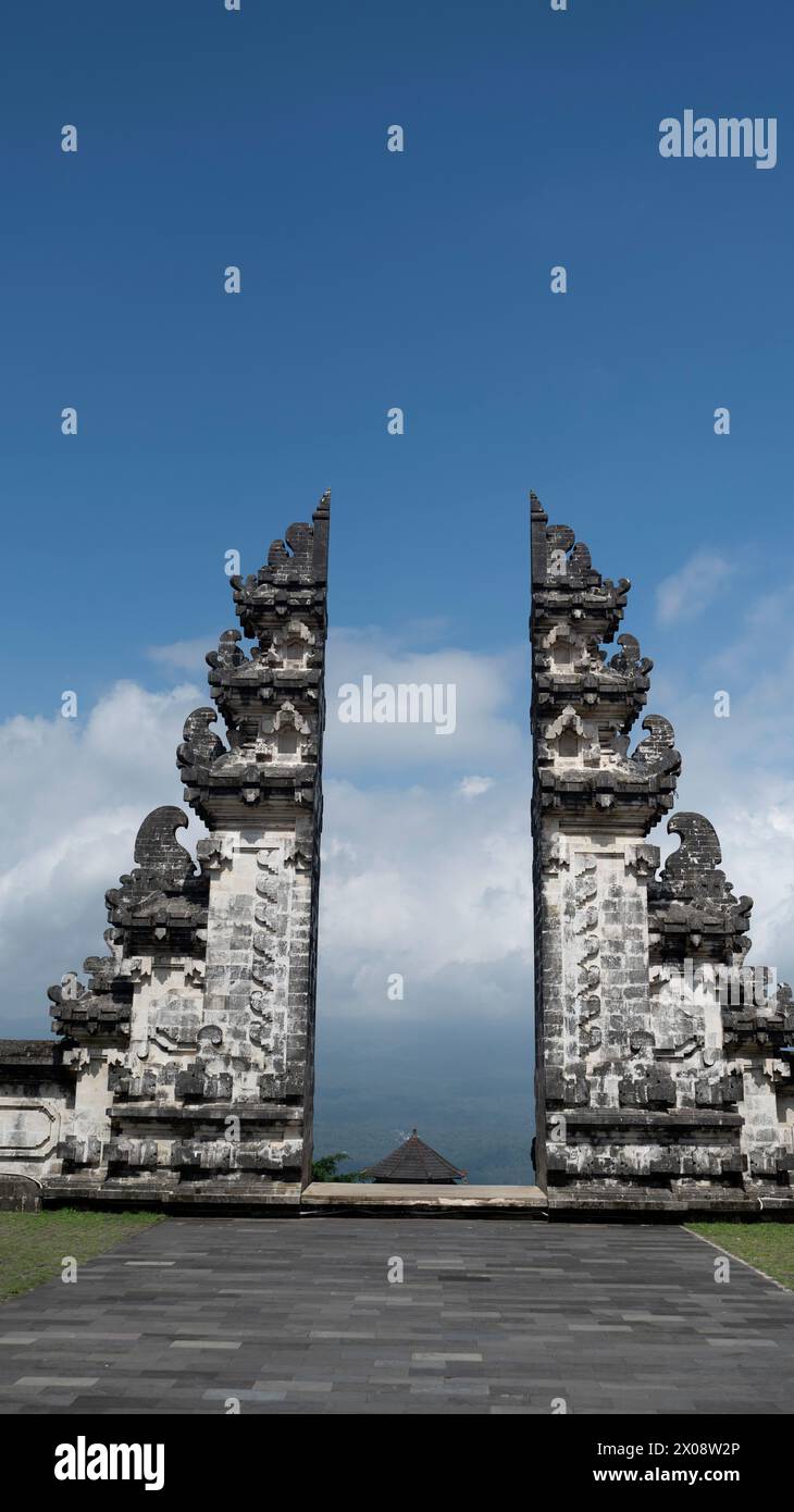 Un'imponente vista della tradizionale porta divisa balinese (Candi Bentar) al tempio pura Lempuyang, Bali, con uno sfondo di cieli nuvolosi Foto Stock