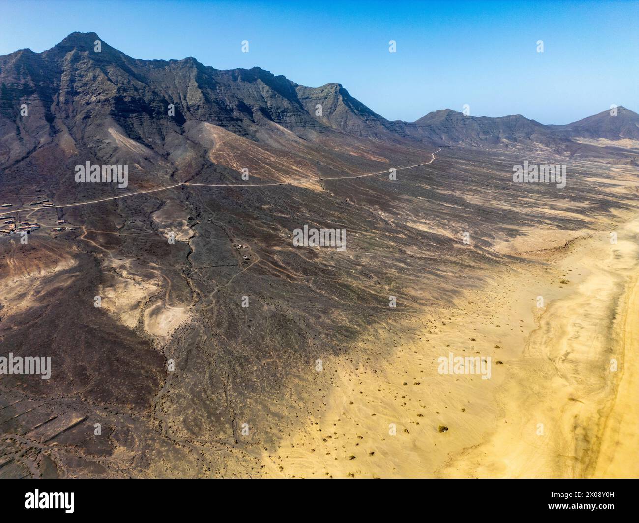 Lo straordinario scatto aereo presenta l'ampio paesaggio desertico e le aspre montagne di Cofete, situato nel sud di Fuerteventura Foto Stock