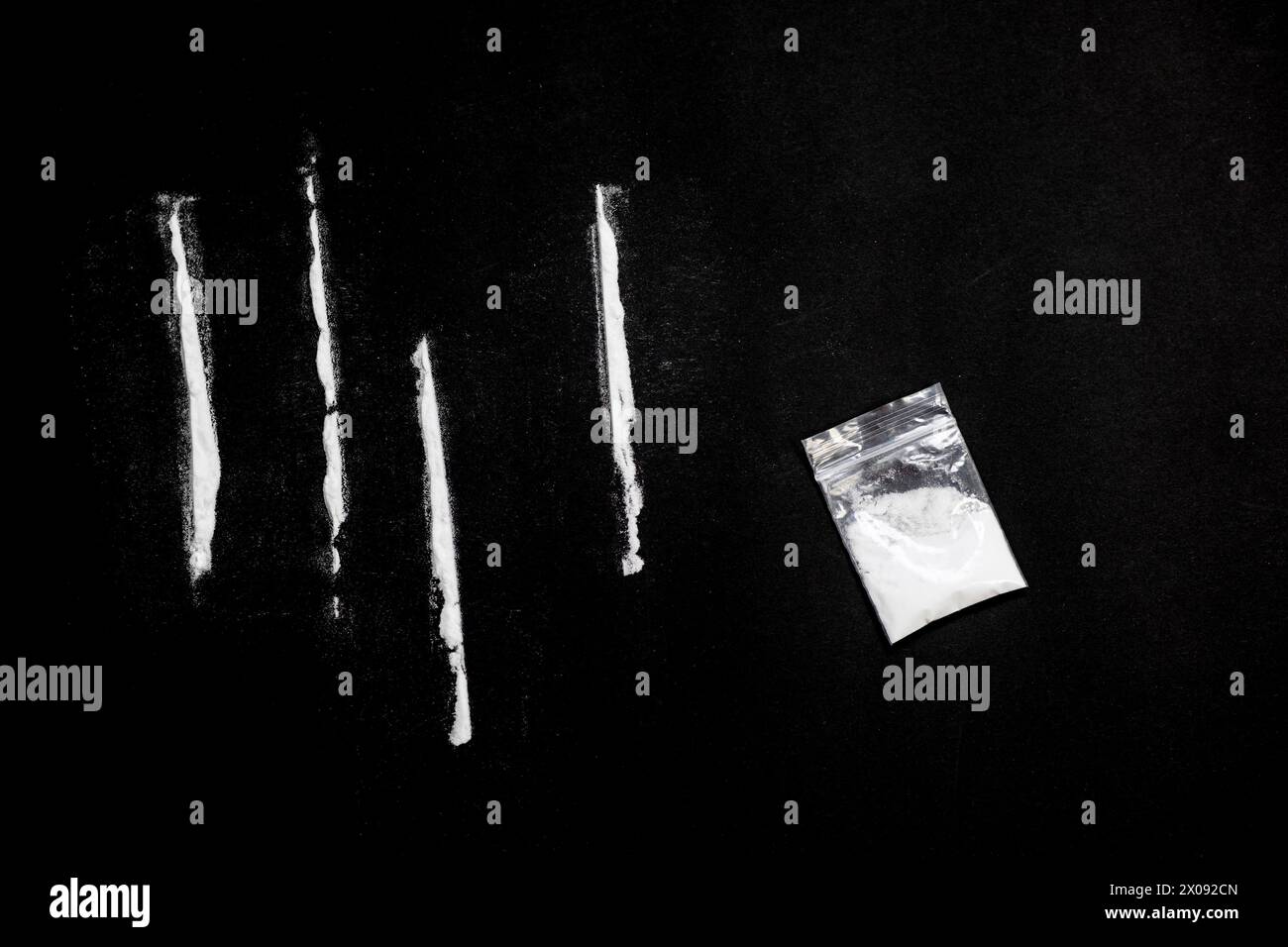 dipendenza da cocaina, droghe pesanti. linee fatte con cocaina su sfondo nero. Foto Stock