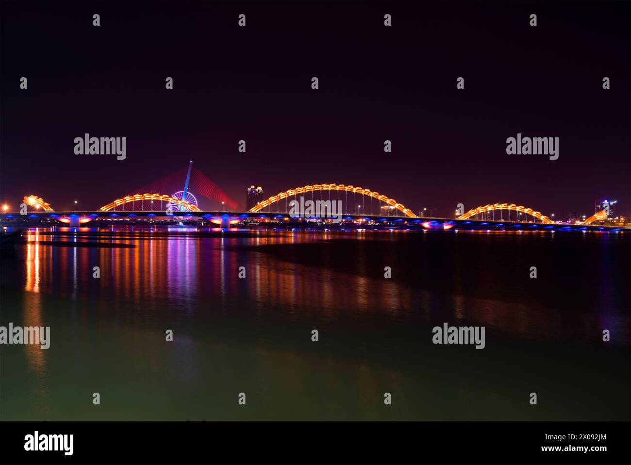 Il Dragon Bridge sul fiume Han con illuminazione notturna. Da Nang, Vietnam Foto Stock