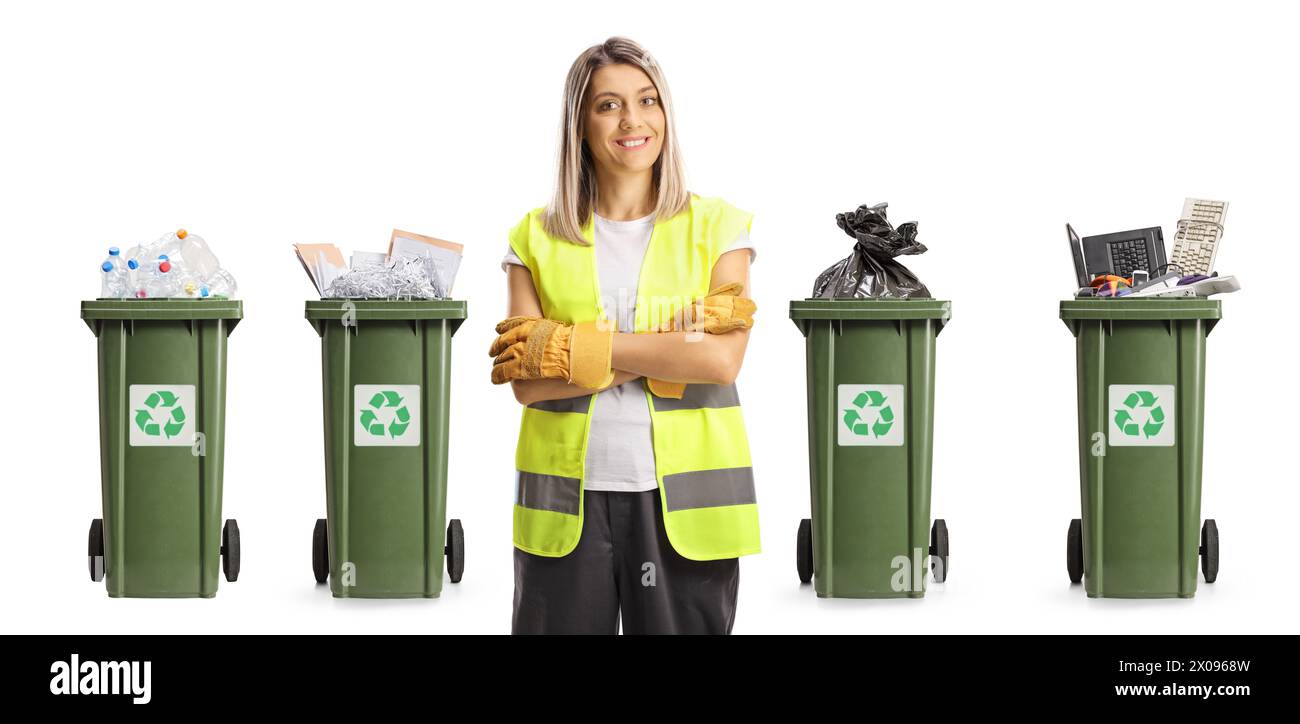 Raccoglitore di rifiuti femmina in uniforme e guanti posizionati davanti ai contenitori con materiali di riciclaggio isolati su sfondo bianco Foto Stock