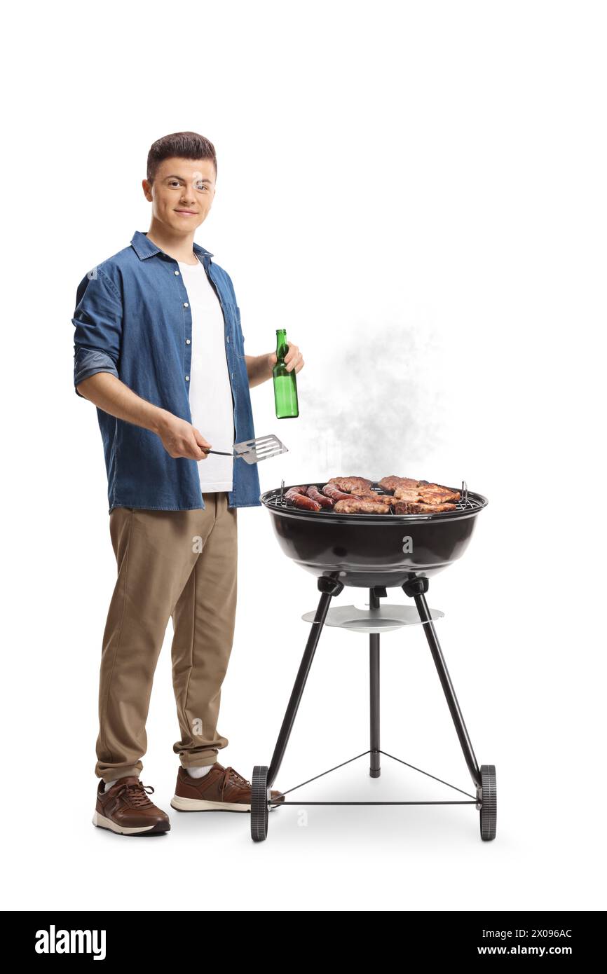 Giovane che prepara un barbecue e tiene in mano una bottiglia di birra isolata su sfondo bianco Foto Stock