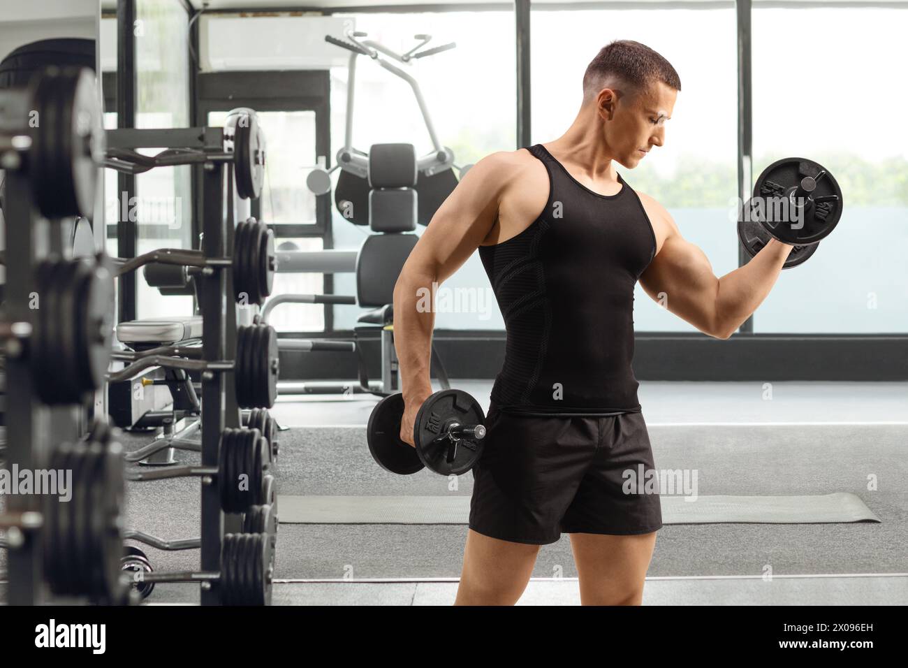 Uomo che esercita il sollevamento pesi in palestra, sport e fitness Foto Stock