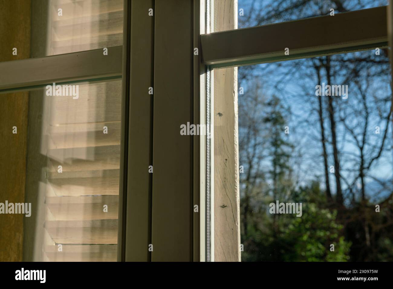 finestra a doppi vetri con effetti di luce e trasparenza, i riflessi solari evidenziano la struttura della finestra e il suo particolare elemento importante Foto Stock