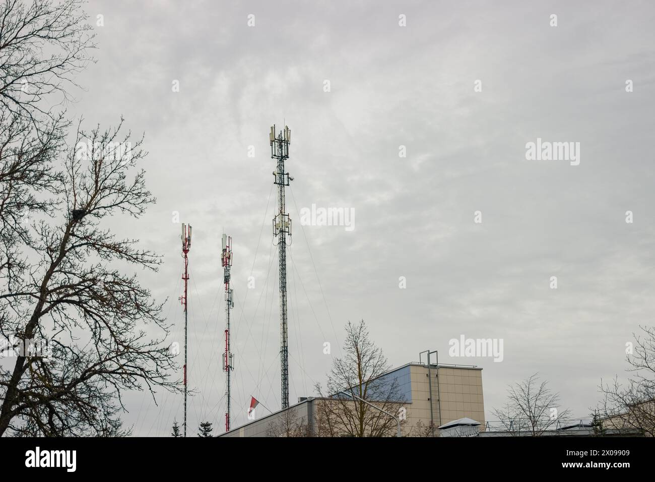 Torre di telecomunicazione con antenna di rete cellulare 5G su sfondo urbano Foto Stock