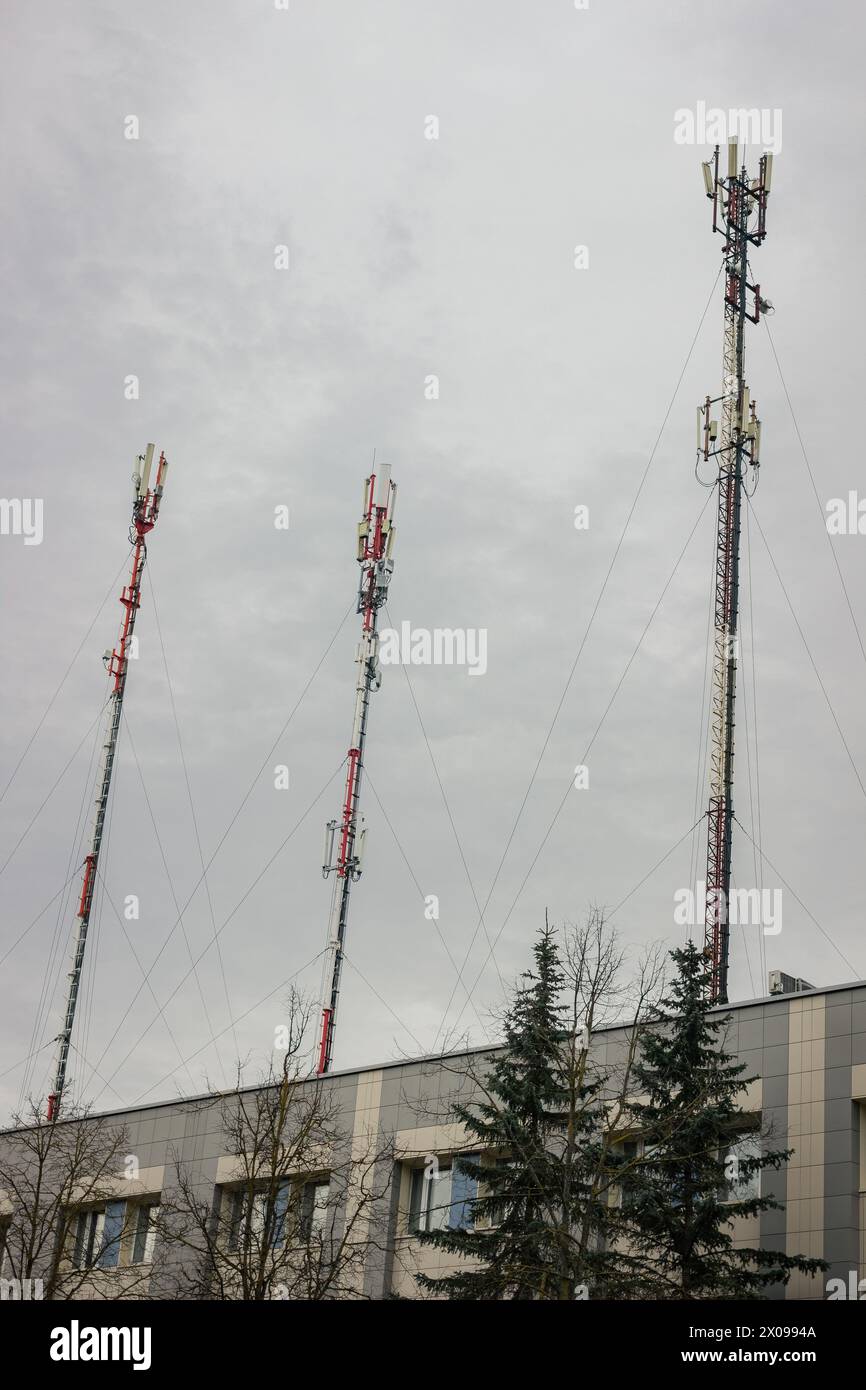 Torre di telecomunicazione con antenna di rete cellulare 5G su sfondo urbano Foto Stock
