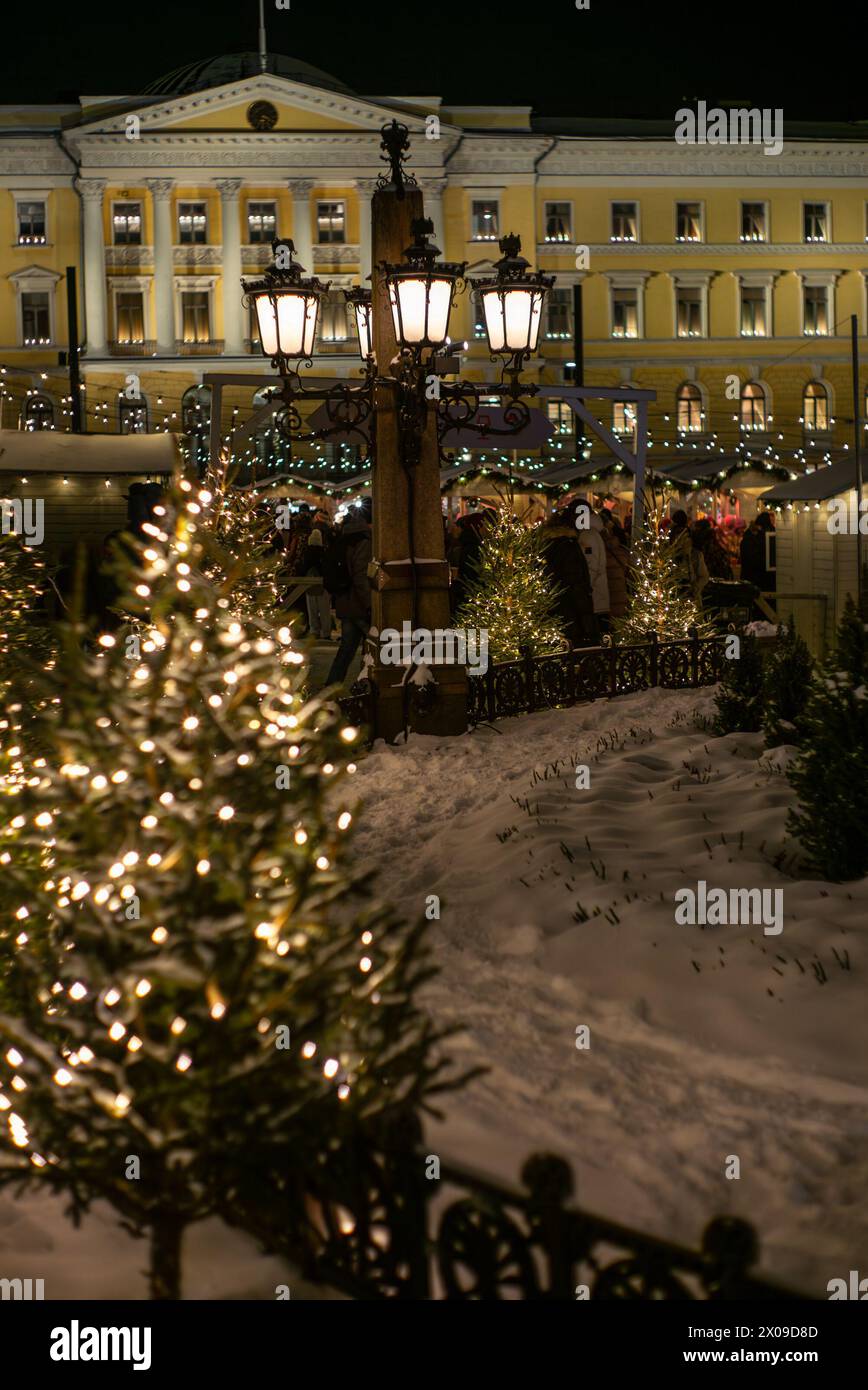 Alberi di Natale, luci e shopping al mercatino di Natale illuminato nella Piazza del Senato di Helsinki Foto Stock