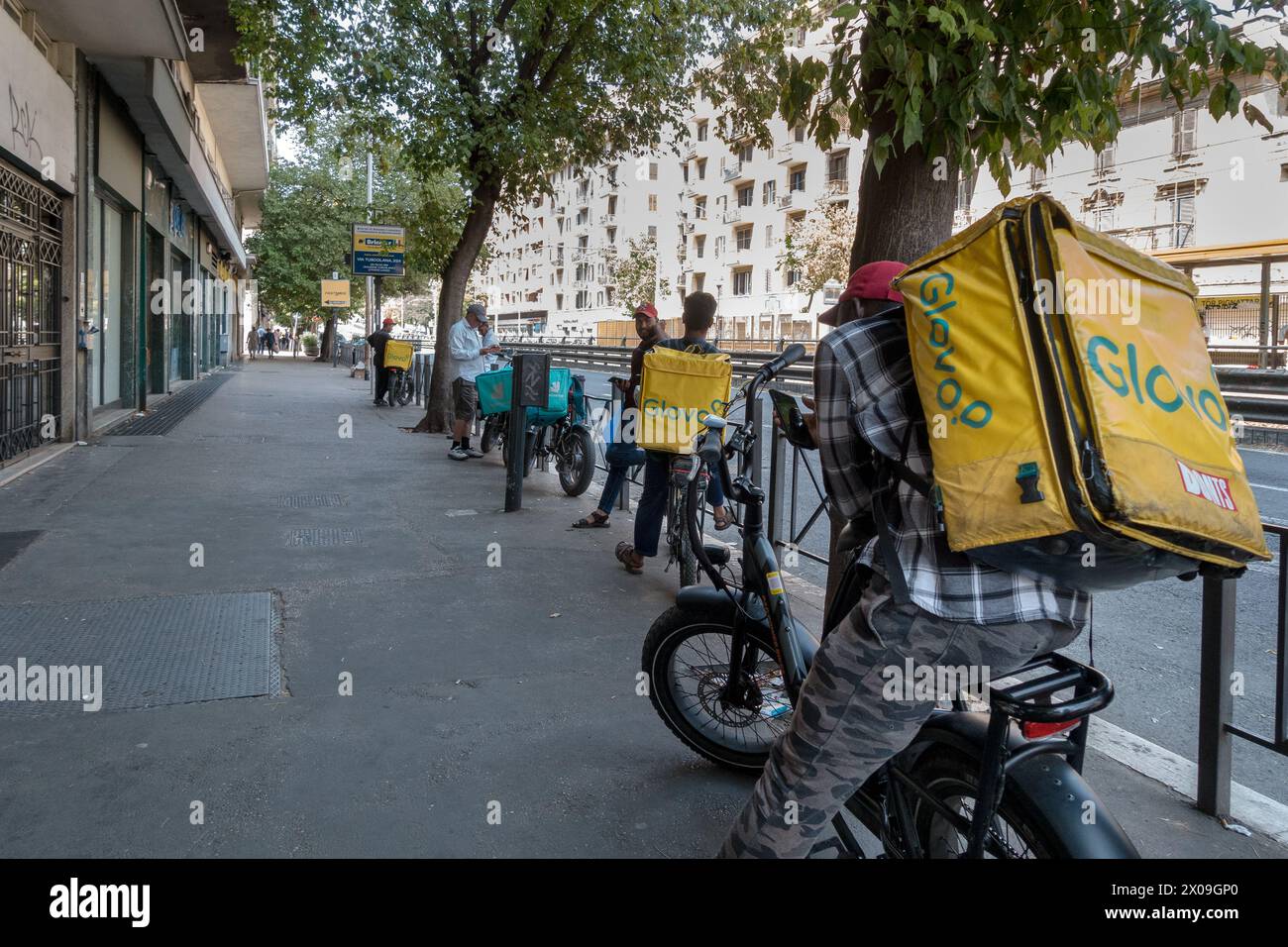 Italia, Roma: I giovani che lavorano per Glovo aspettano di partire con un ordine da consegnare Foto Stock