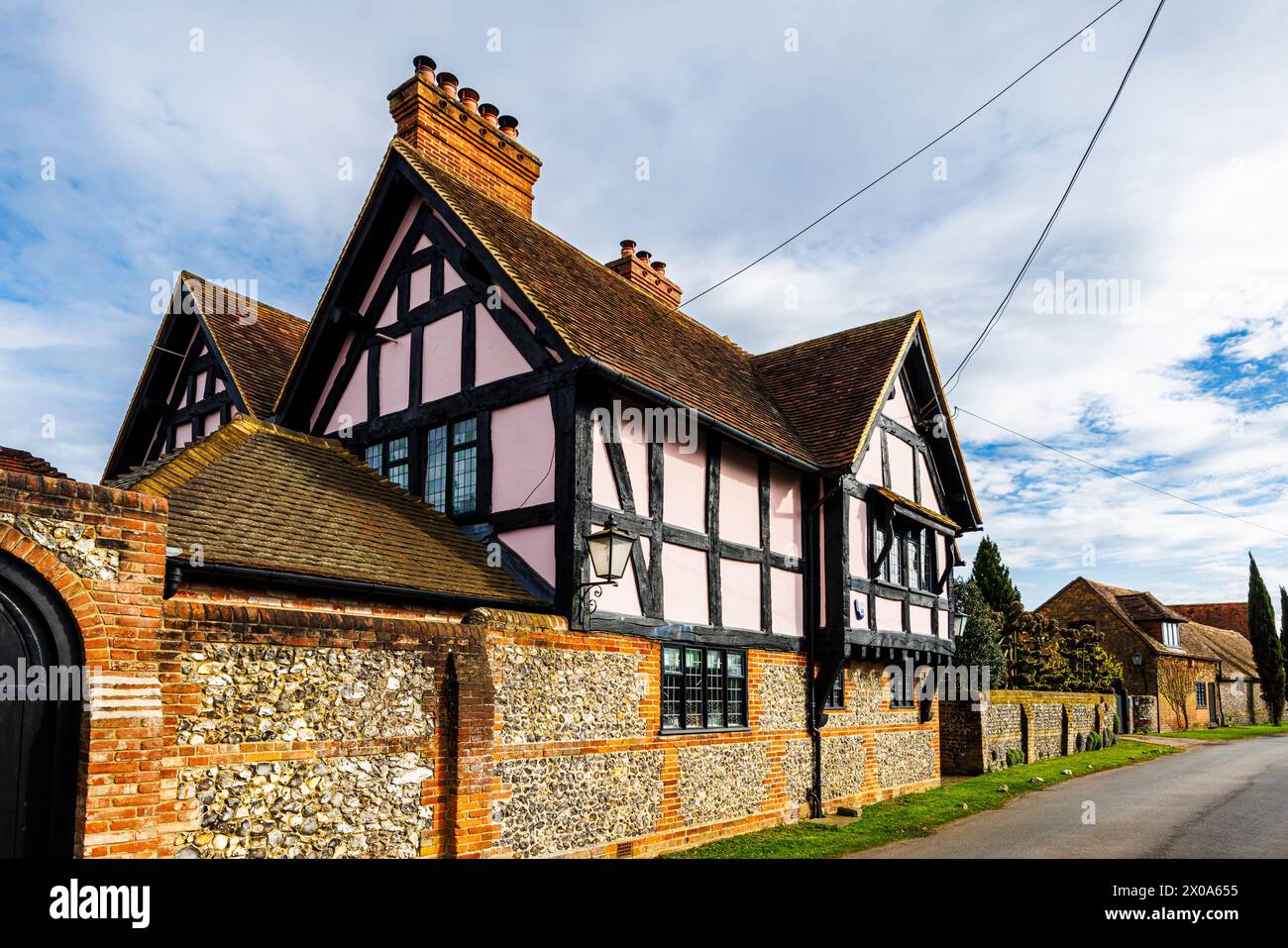 Vista sulla strada di una grande casa in legno rosa di lusso a Bix, un grazioso e pittoresco villaggio di campagna vicino a Henley-on-Thames, nel sud dell'Oxfordshire Foto Stock