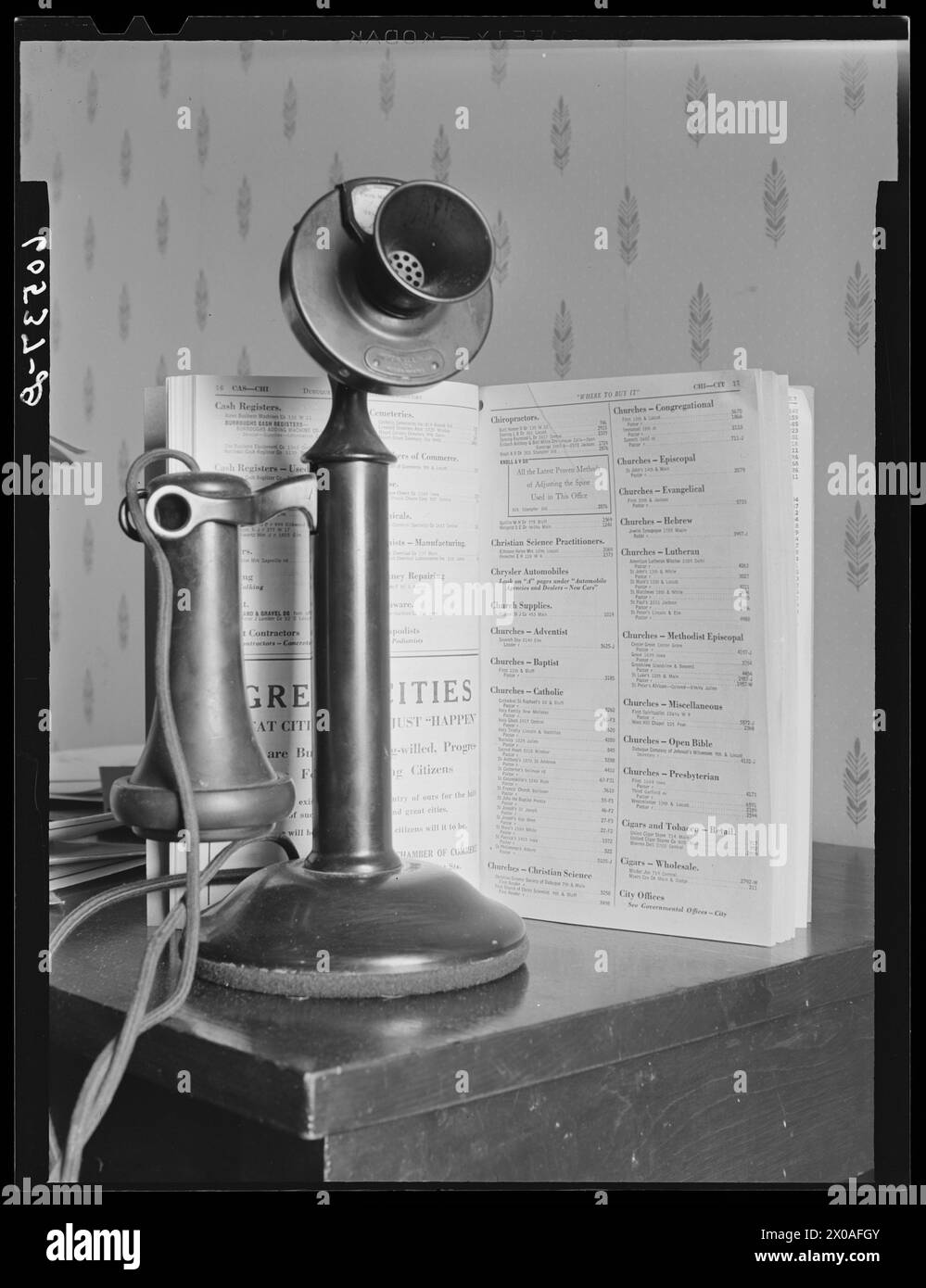 Telefono vecchio stile con elenco telefonico stampato su supporto in legno, Dubuque, Iowa, aprile 1940. (Foto di John Vachon/Office of War Information) Foto Stock