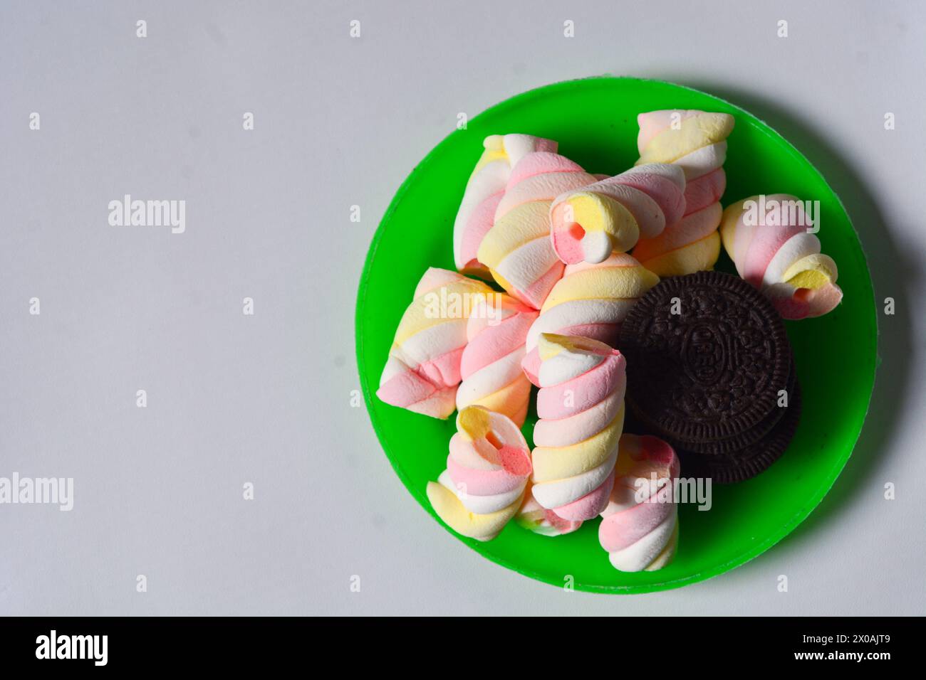 11 maggio 2023, Wonosobo Indonesia: Foto di oreos e marshmallow su un piccolo piatto verde su sfondo bianco. Foto Stock