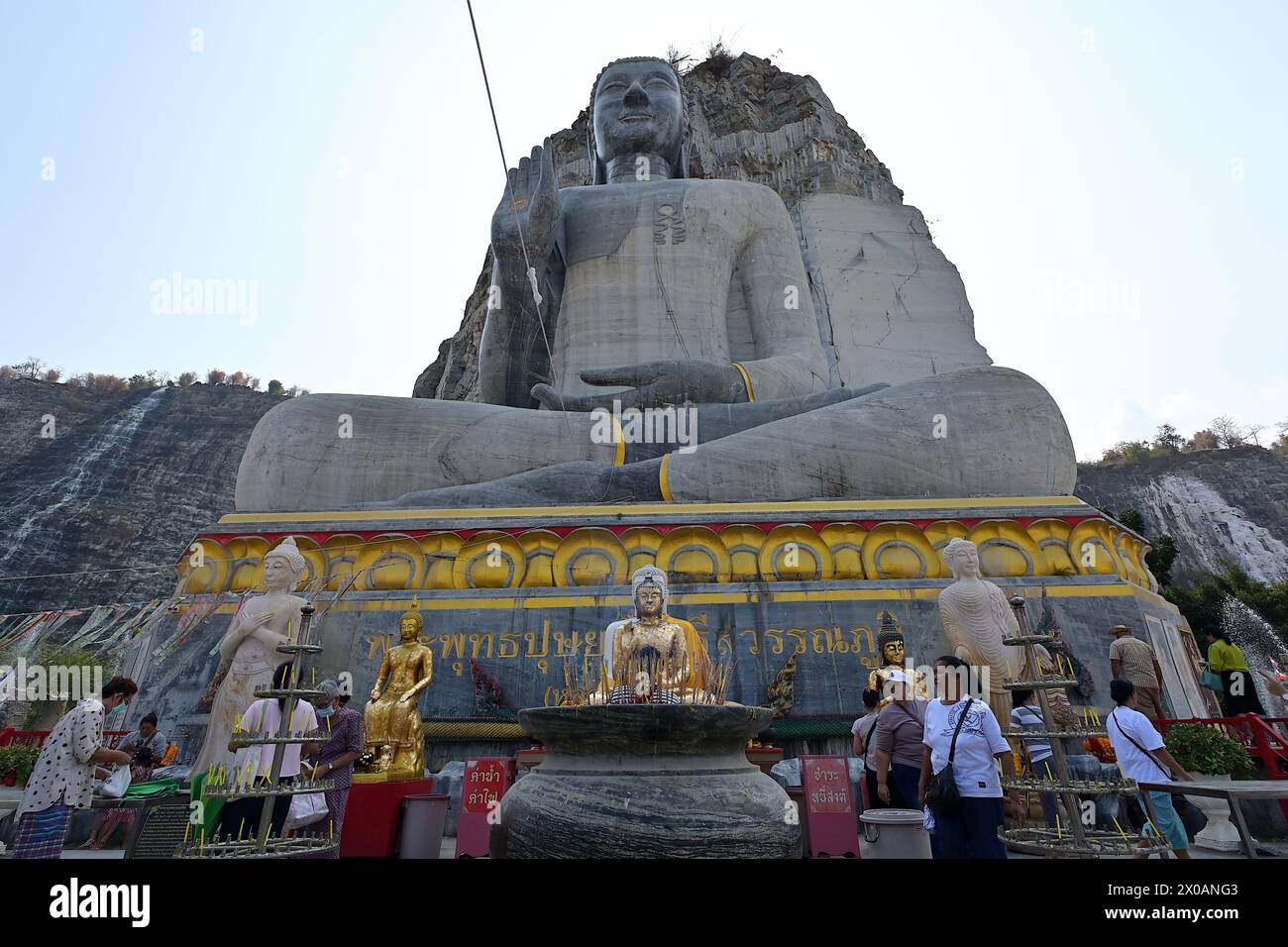 Primo piano di una grande scultura di Buddha di Luang Pho U Thong seduta con la mano destra nel mudra di gyan, scolpita da una scogliera nella provincia di Suphanburi Foto Stock