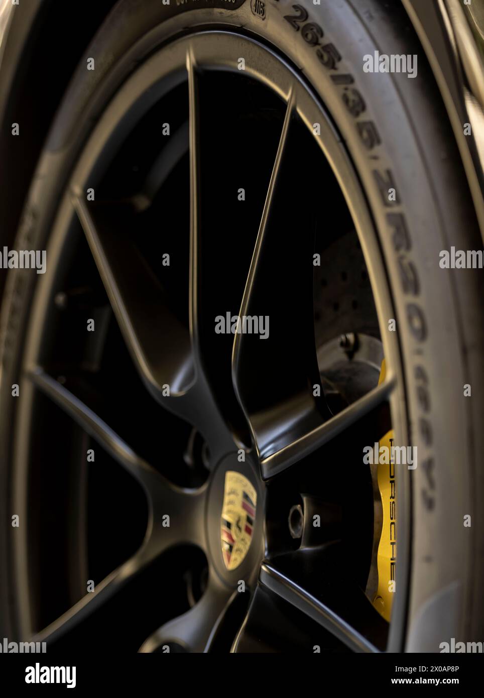 Immagine di dettaglio di una costosa ruota nera e del coperchio del freno a disco giallo su una porsche Foto Stock