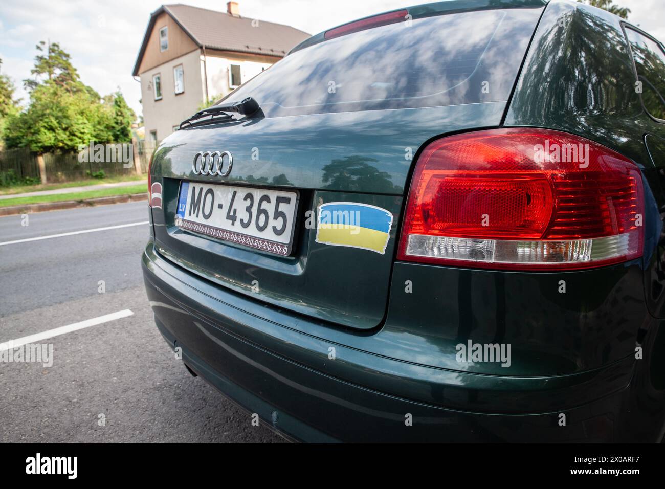 Immagine di un'auto lettone con bandiera ucraina in piedi per le strade di riga, che celebra nuovamente la solidarietà tra Lettonia e Ucraina nella guerra Foto Stock