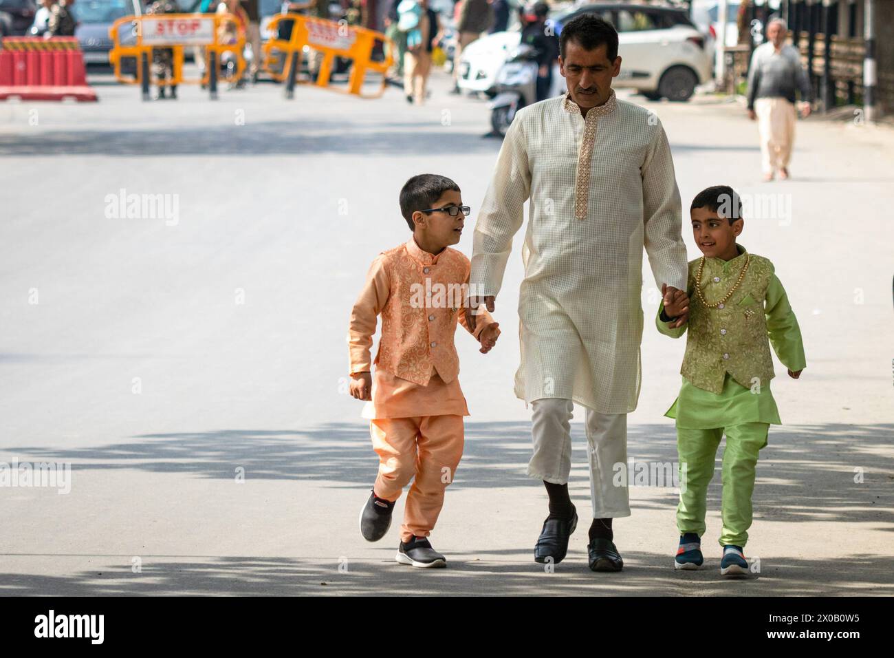 Srinagar, India. 10 aprile 2024. Un uomo Kashmiri insieme ai suoi figli camminano verso la moschea per offrire preghiere Eid-al-Fitr a Srinagar. Il festival EID-al-Fitr segna la fine del santo mese di digiuno del Ramadan. Nel frattempo, le autorità indiane hanno impedito alle persone di offrire preghiere Eid-al-Fitr nella storica grande Moschea del Kashmir, o Jamia Masjid, per il quinto anno consecutivo nel centro di Srinagar. (Foto di Faisal Bashir/SOPA Images/Sipa USA) credito: SIPA USA/Alamy Live News Foto Stock