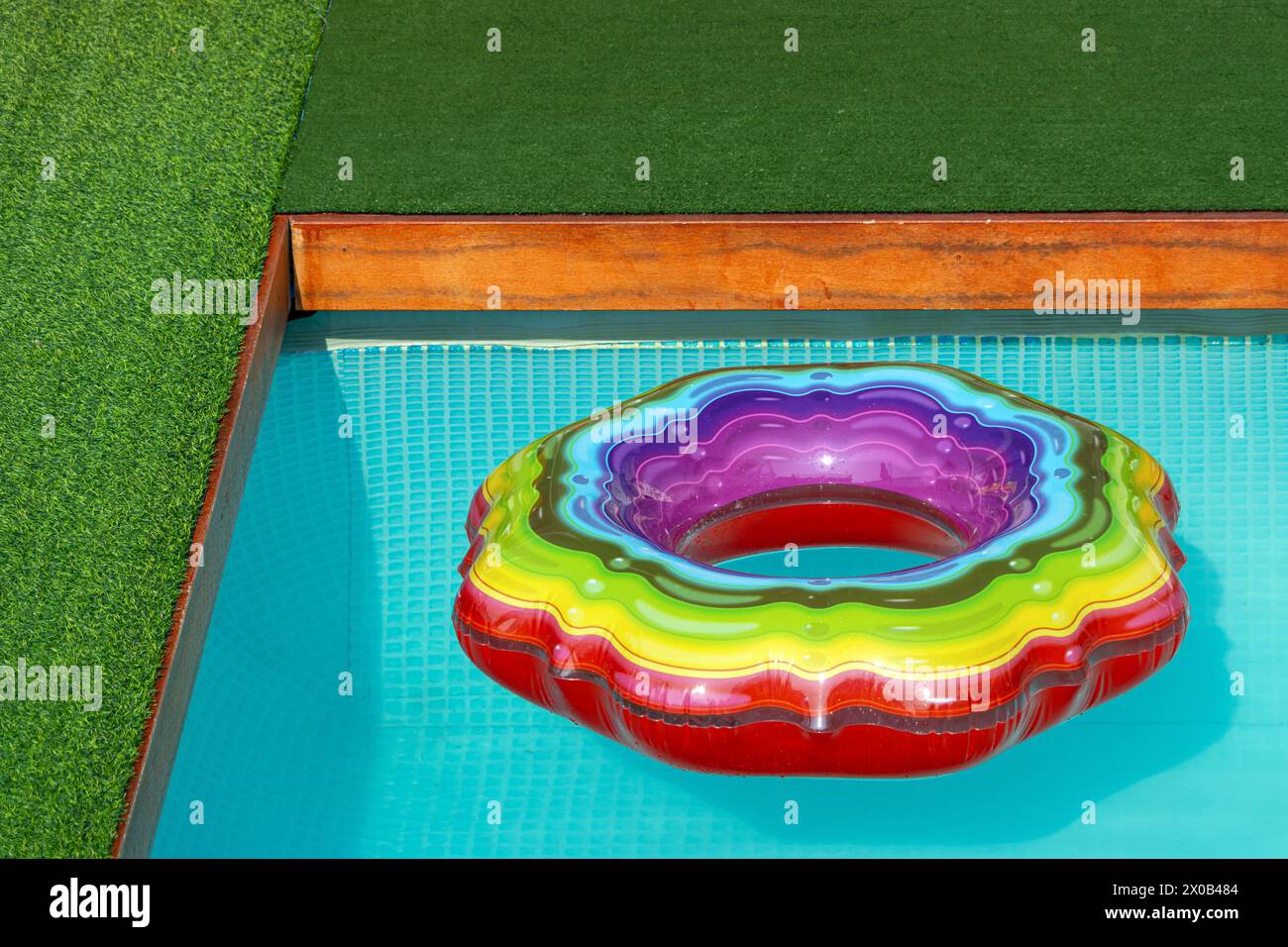 Colorato anello gonfiabile sulla superficie della piscina Foto Stock