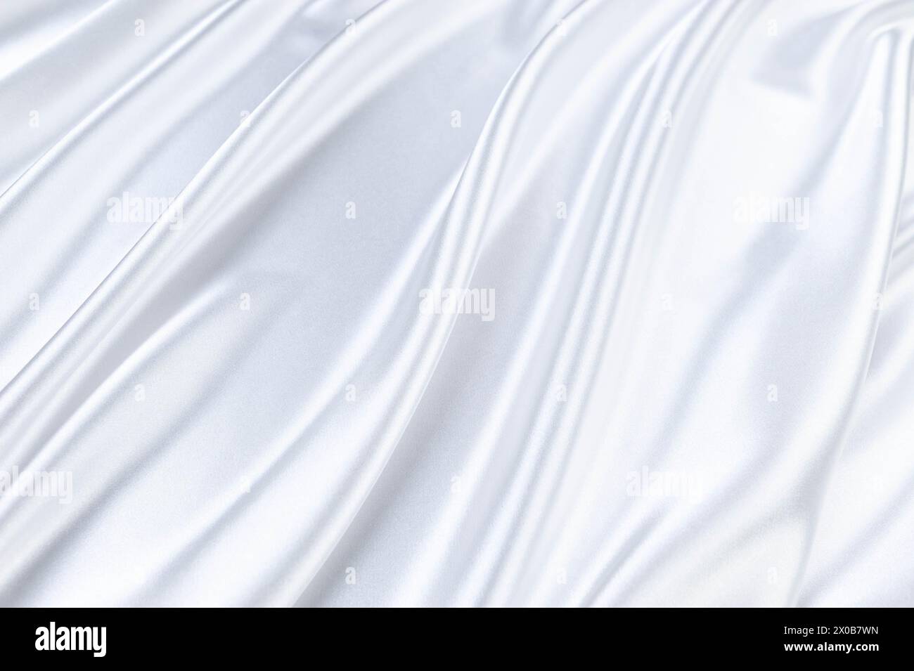 Lussuoso sfondo bianco satinato. Tessuto di seta morbido ed elegante. Tessuto ondulato. Vista dall'alto. Foto Stock