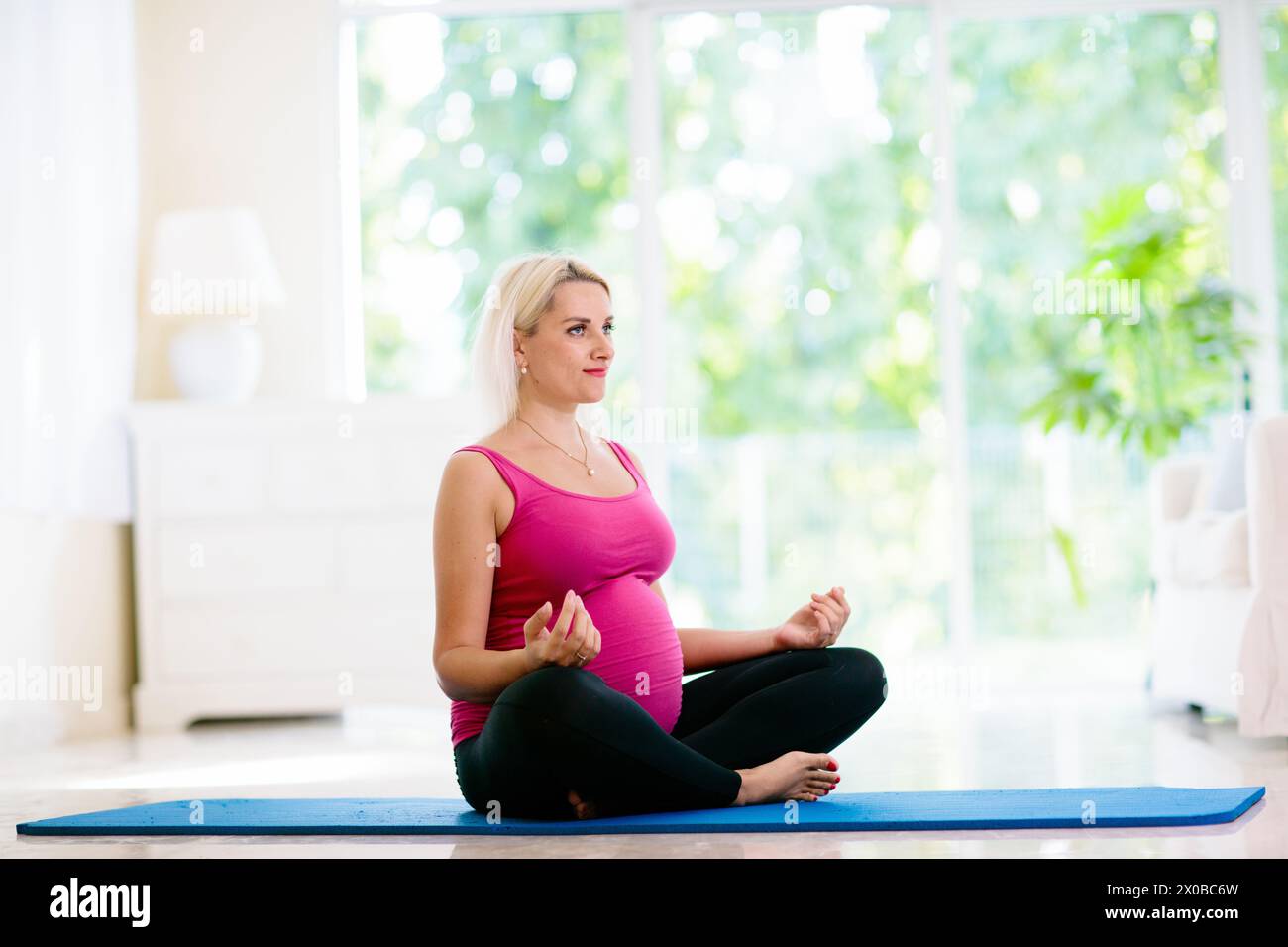 Gravidanza yoga. Esercizio per la donna incinta. Attiva giovane donna che si esercita a casa o in palestra. Nuova mamma in attesa che si mantenga attiva e in forma Foto Stock