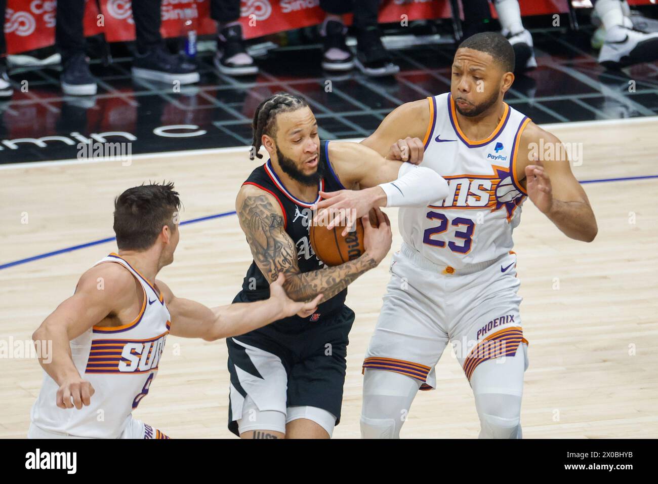 Los Angeles, Stati Uniti. 10 aprile 2024. L'Amir Coffey (C) dei Los Angeles Clippers è tra Eric Gordon (R) dei Phoenix Suns e Grayson Allen durante la partita di regular season NBA del 2023-2024 tra Los Angeles Clippers e Phoenix Suns a Los Angeles, negli Stati Uniti, 10 aprile 2024. Crediti: Ringo Chiu/Xinhua/Alamy Live News Foto Stock