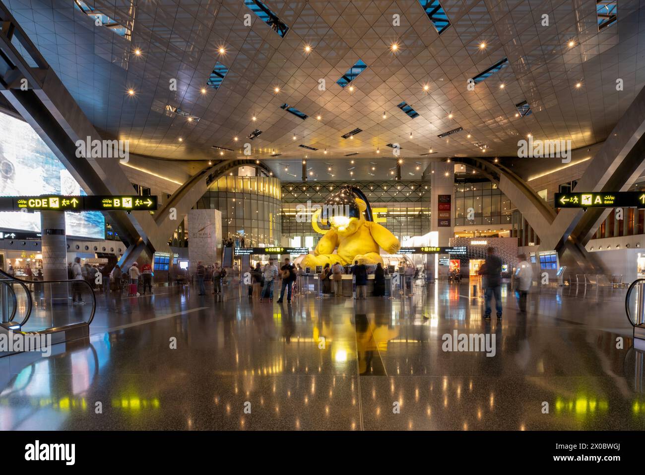 Terminal dell'aeroporto internazionale di Hamad con tutti i cancelli e i viaggiatori che passano. Foto Stock