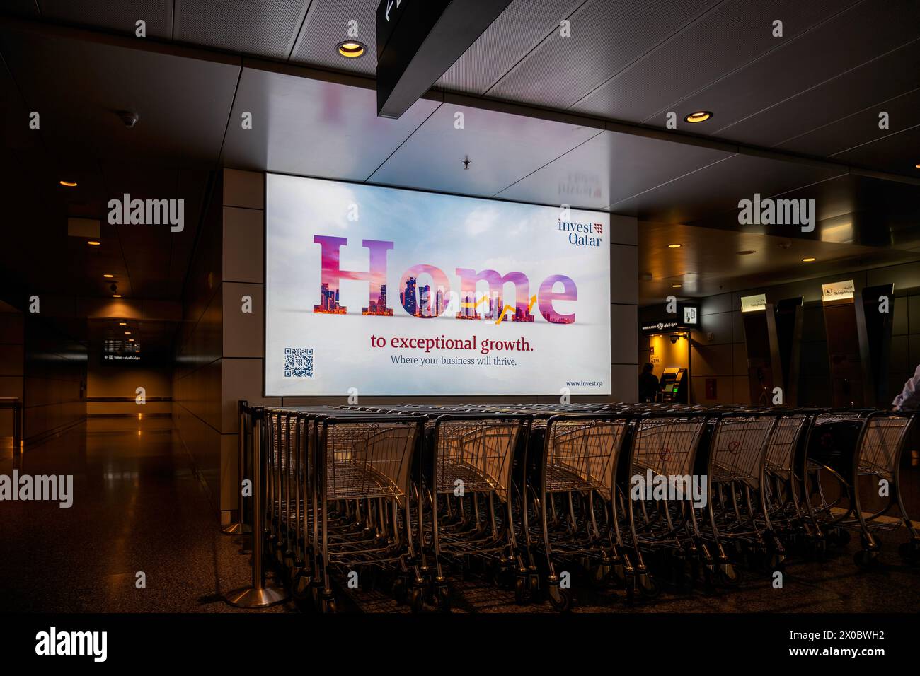 Terminal dell'aeroporto internazionale di Hamad con tutti i cancelli e i viaggiatori che passano. Foto Stock