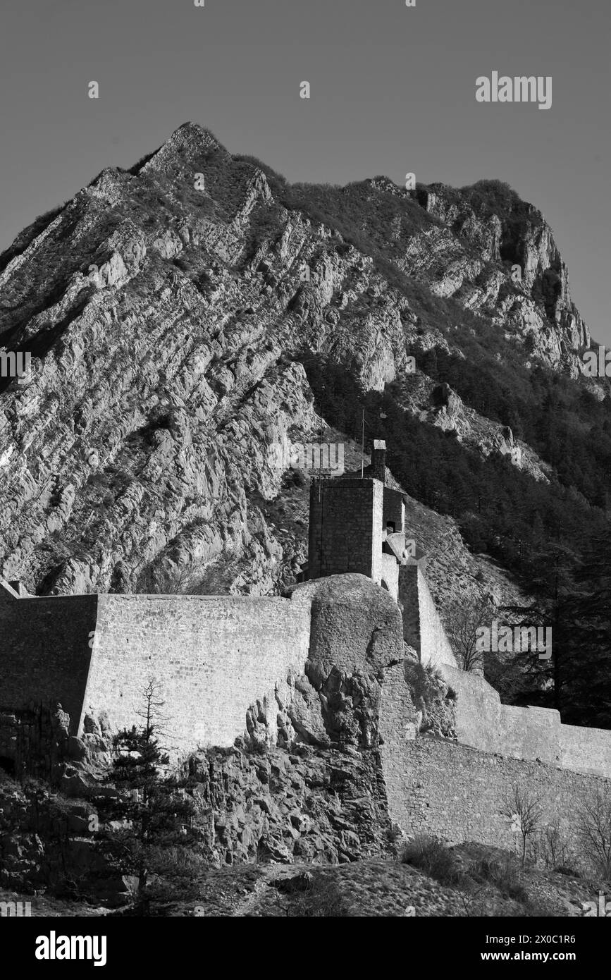 Bianco e nero o monocromatico Vista della Cittadella di Sisteron, della Fortezza, del forte o del Castello e della formazione rocciosa di la Baume Alpes-de-Haute-Provence Provenza Francia Foto Stock