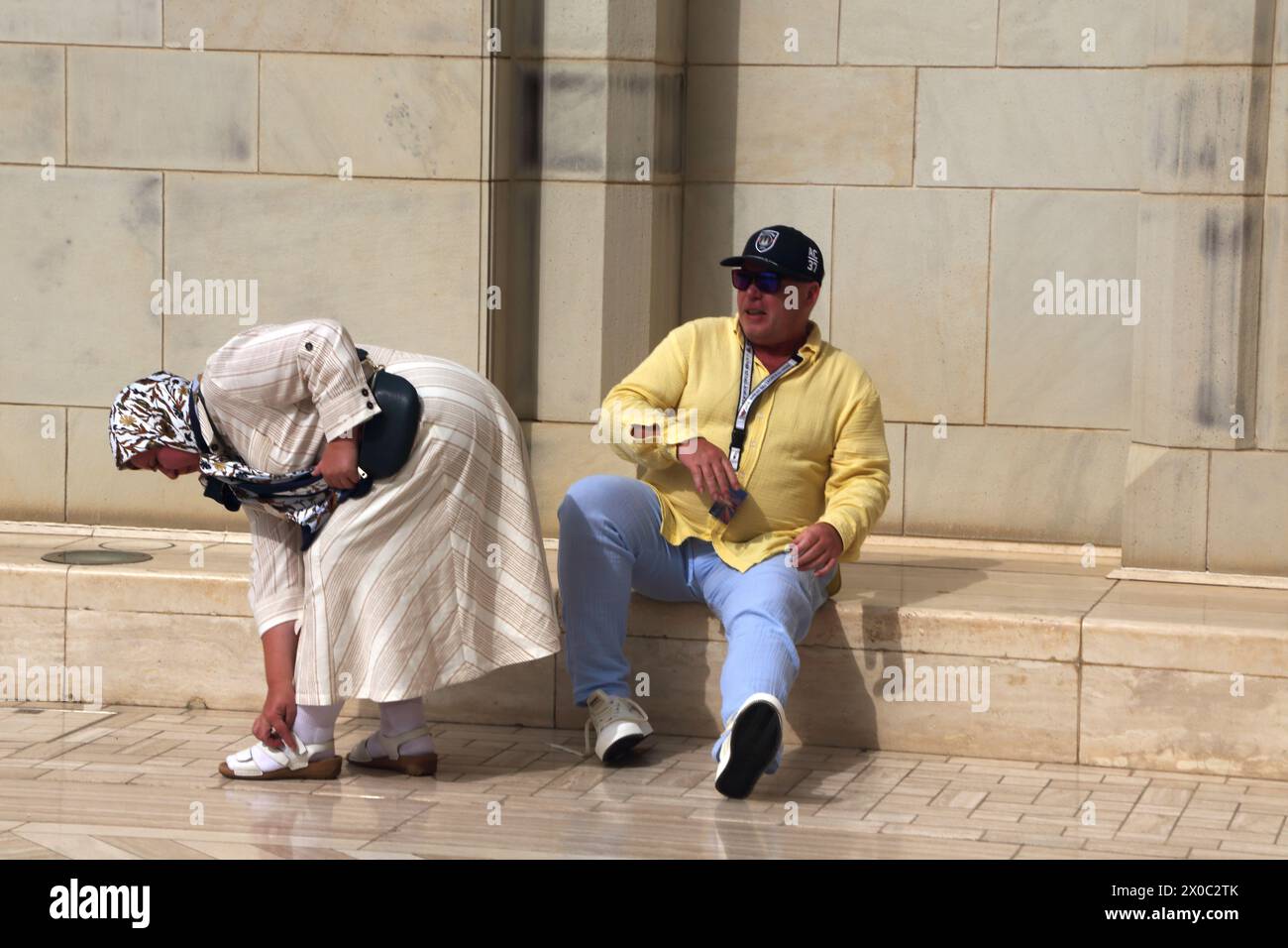 Gran Moschea del Sultano Qaboos turisti nel cortile (Sahn) che tolgono le scarpe prima di entrare nella Moschea di Mascate Oman Foto Stock