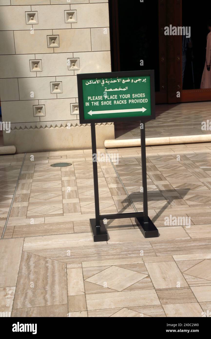 Grande Moschea del Sultano Qaboos con il cartello bilingue decorato in legno "si prega di posizionare le scarpe negli appositi portascarpe forniti" Muscat Oman Foto Stock Grande Moschea del Sultano Qaboos con il cartello bilingue decorato in legno "si prega di posizionare le scarpe negli appositi portascarpe forniti" Muscat Oman Foto Stock