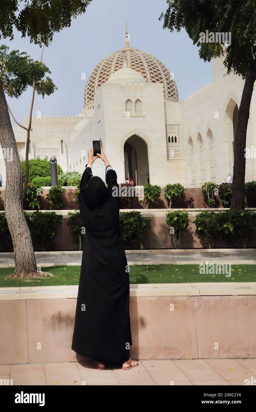 Gran moschea Sultan Qaboos donna che scatta fotografie con smartphone Muscat Oman Foto Stock