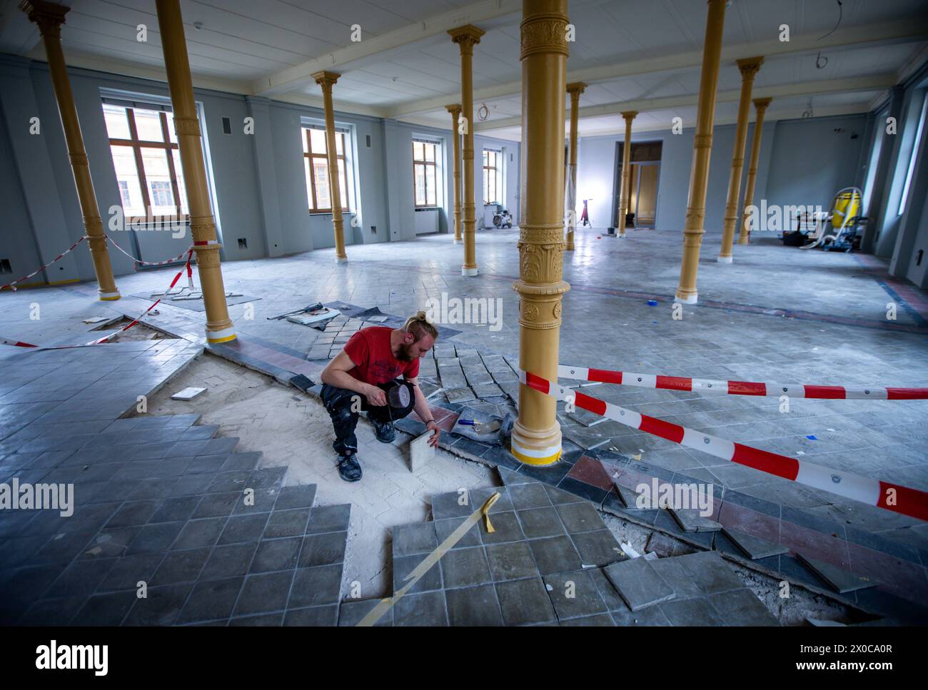 Schwerin, Germania. 11 aprile 2024. Vincent Waldhelm del dipartimento di conservazione del patrimonio di Mühlhausen lavora su piastrelle storiche in una delle sale espositive del Museo di Stato. I lavori di riconversione dell'edificio sono in corso, con 10 milioni di euro e due anni di lavori attualmente in corso per l'ampia ristrutturazione del museo e la creazione di moderni spazi espositivi. Il museo riaprirà ai visitatori nell'estate 2025 con un nuovo concetto di illuminazione e colore. Crediti: Jens Büttner/dpa/Alamy Live News Foto Stock