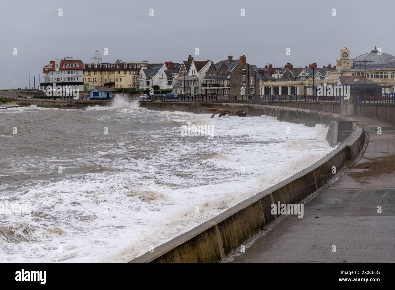 Le maree primaverili si infrangono contro la banchina lungo la passeggiata di Porthcawl, nel Galles del Sud, durante il maltempo costiero. Foto Stock