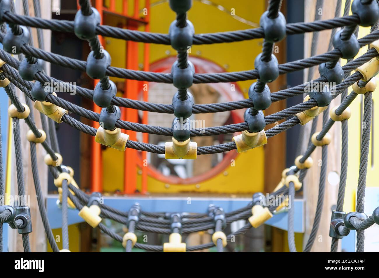 Vista ravvicinata del colorato ponte di corda del parco giochi per le attrezzature ricreative all'aperto dei bambini in un parco pubblico. Garantire la sicurezza e la durata di a. Foto Stock