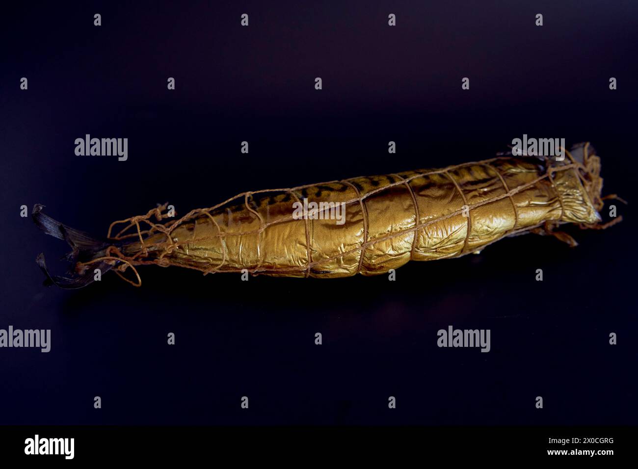 Appetitosi sgombri dorati affumicati su sfondo nero Foto Stock