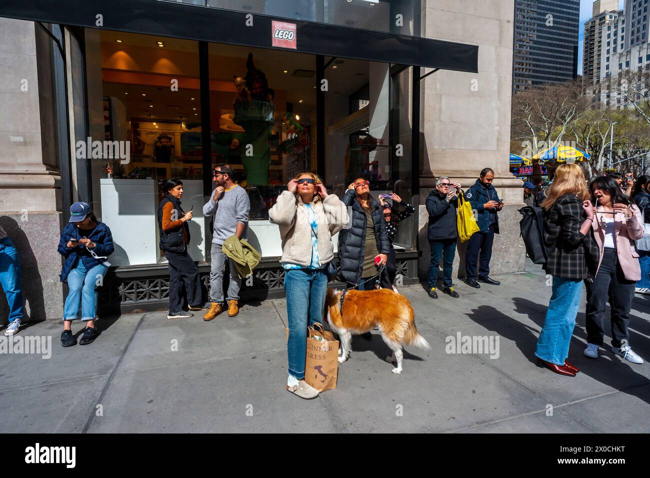 Centinaia di persone si riuniscono al Flatiron Plaza di New York per una festa di osservazione da guardare, indossando la protezione per gli occhi, l'eclissi solare di lunedì 8 aprile 2024. New York City non era nel percorso della totalità con la luna che copriva il 89% del sole durante la finestra dalle 15:15 alle 15:30. (© Richard B. Levine) Foto Stock