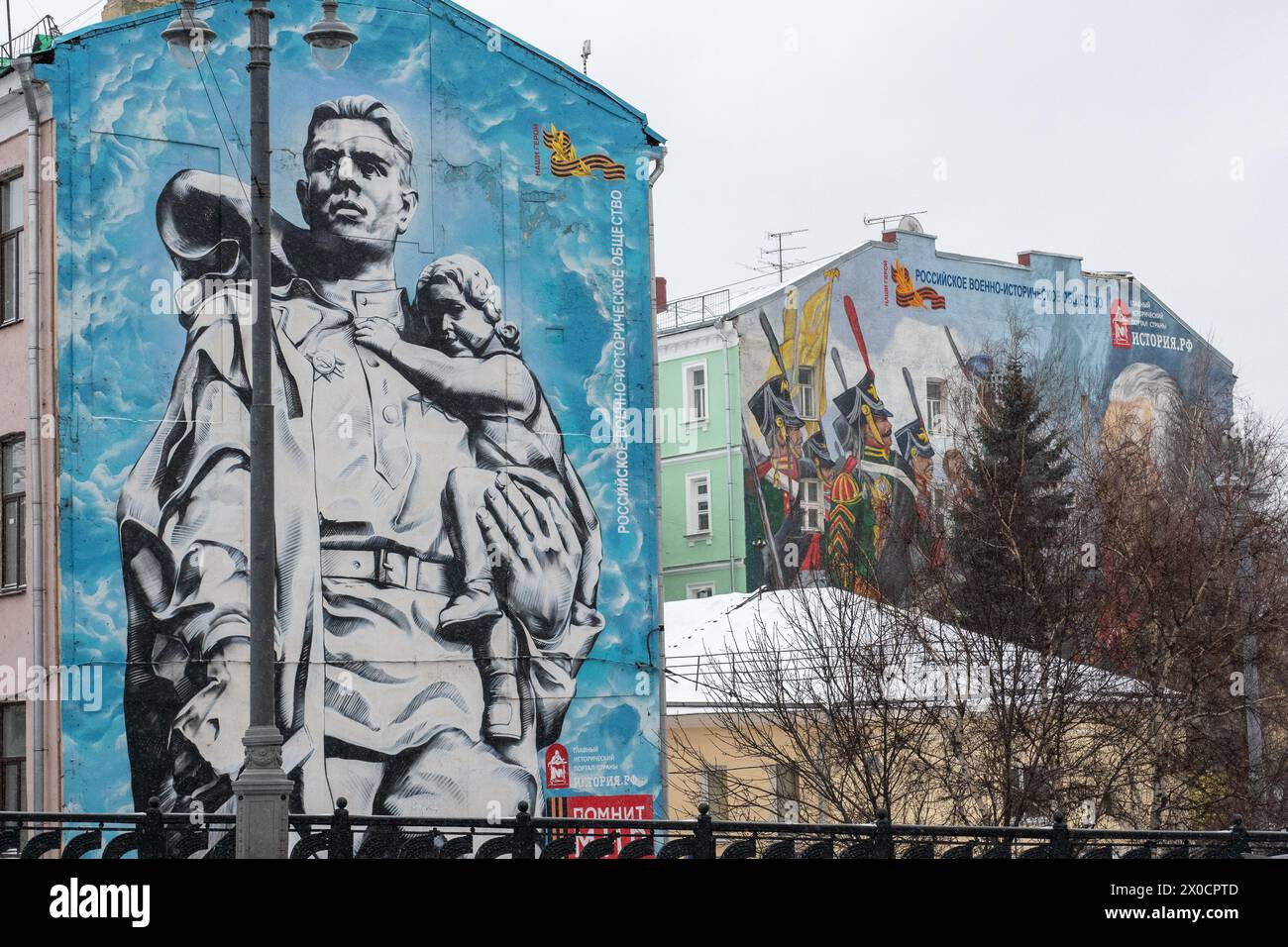 Mosca, Russia - 17 gennaio 2018: Due murales su larga scala, ognuno che narra silenziosamente una storia di coraggio e onore, adornano le facciate degli edifici sotto il tr Foto Stock