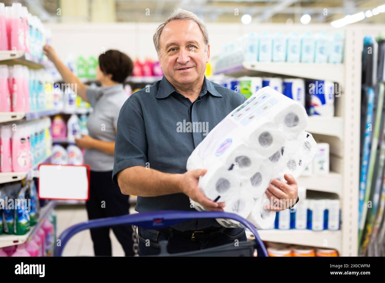 L'uomo anziano sceglie la carta igienica nel supermercato Foto Stock