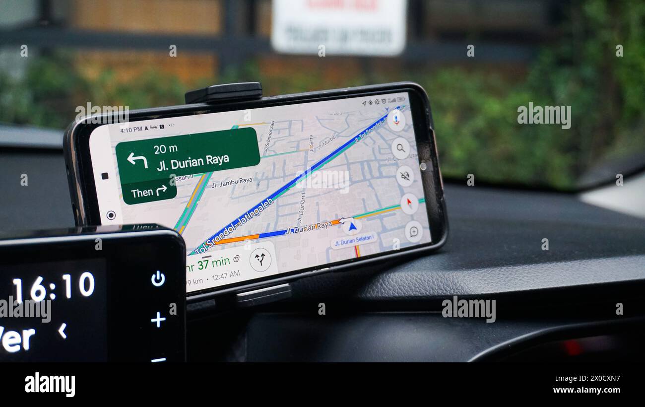 applicazione, utilizzo di google maps su uno smartphone in auto. semarang, 13 aprile 2024. Foto Stock
