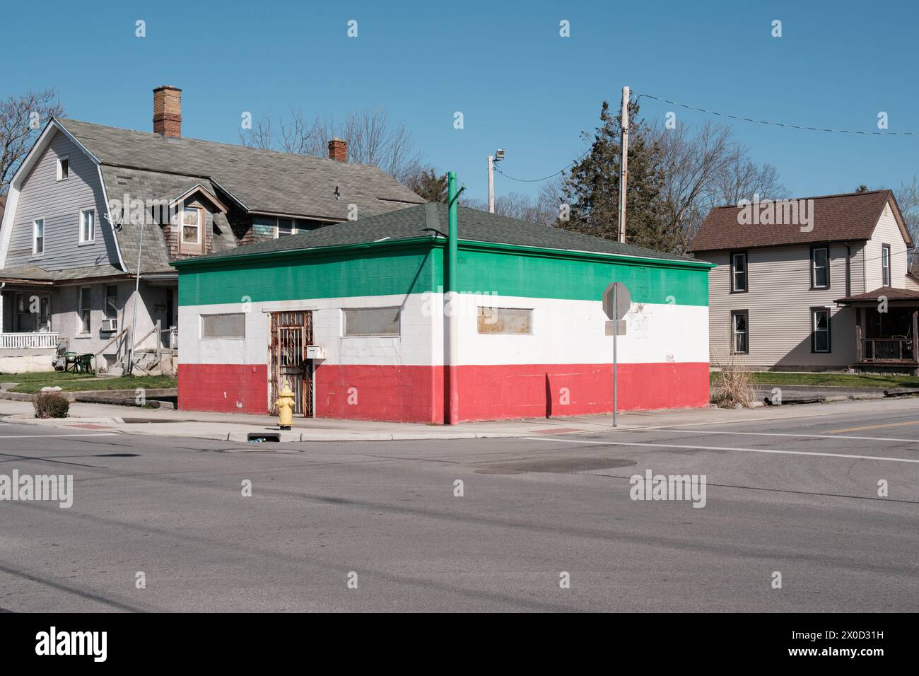 Negozio abbandonato con mattoni verniciati verde bianco e rosso, a Lima Ohio USA Foto Stock