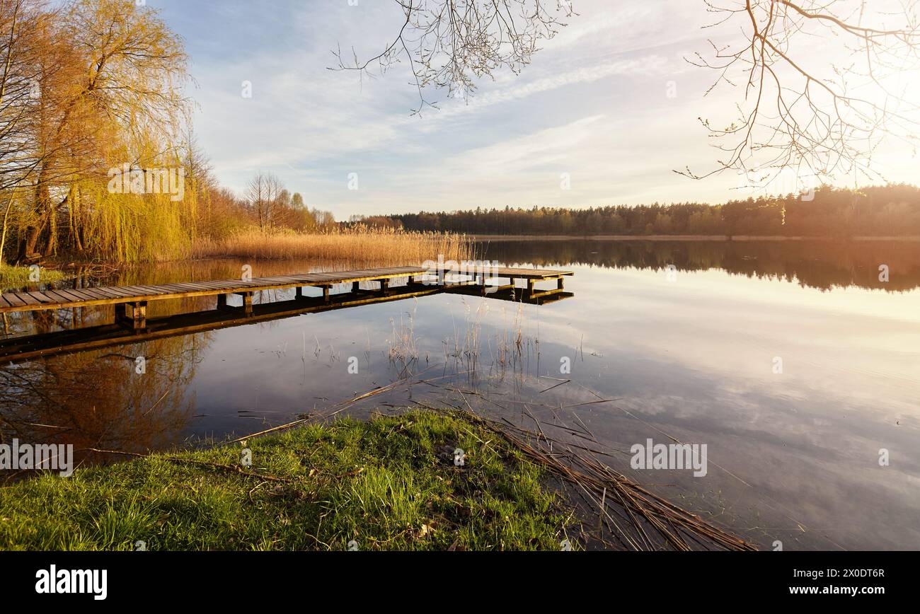 Tramonto panoramico con un molo su un lago vicino alla città di Recz, Voivodato della Pomerania Occidentale, Polonia. Foto Stock