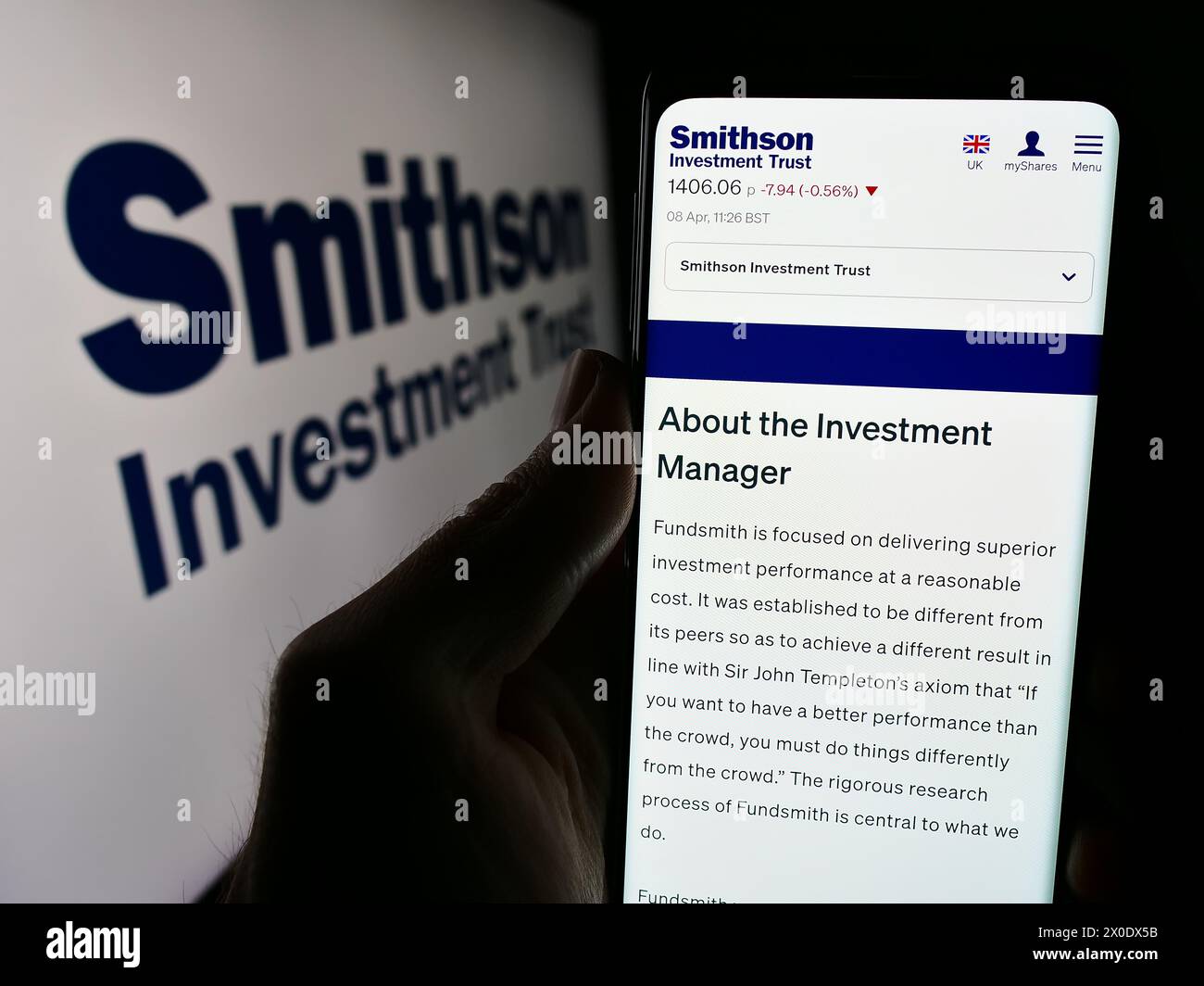 Persona che detiene un telefono cellulare con il sito web della società britannica Smithson Investment Trust plc davanti al logo. Messa a fuoco al centro del display del telefono. Foto Stock
