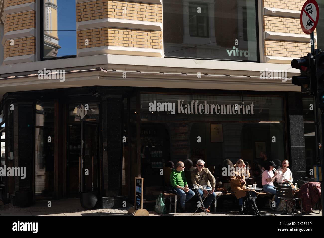 I norvegesi si siedono fuori da una caffetteria Kaffebrenneriet nel centro di Oslo al sole primaverile, in Norvegia, Scandinavia Foto Stock